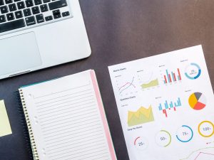 Laptop, Blick, Grafiken liegen auf einem Tisch