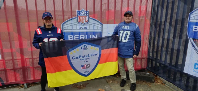 Zwei GPC-Mitglieder halten eine Fanclub-Fahne hoch.