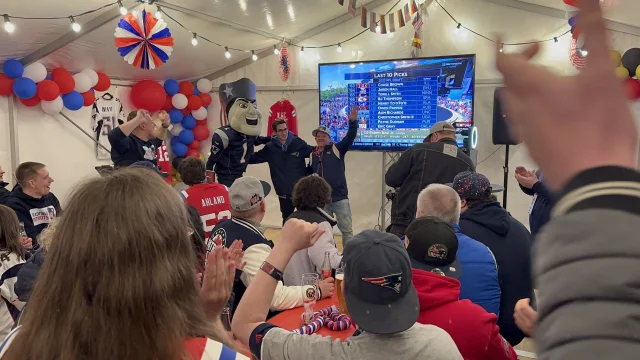 Eine Gruppe Patriots-Fans macht Fotos von Pat Patriot und einem GPC-Mitlglied, das gerade etwas gewonnen hat.