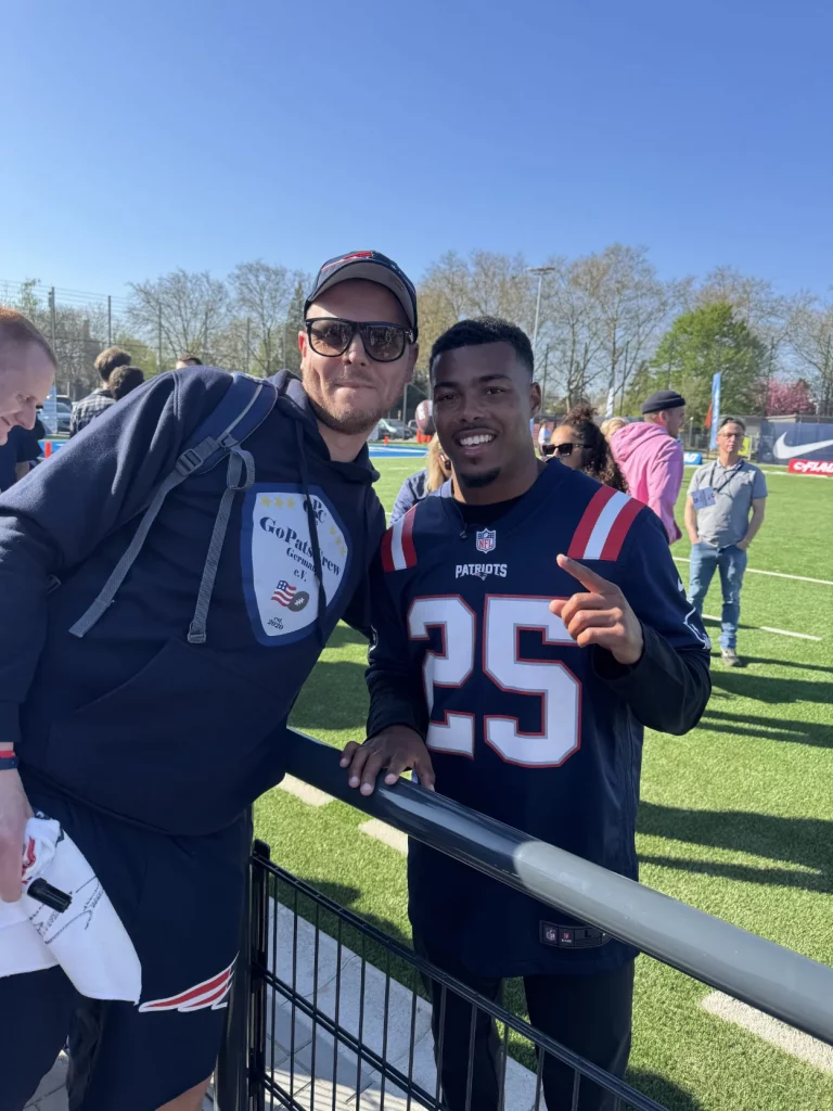 Ein Mitglied und Marcus Jones posieren f&uuml;r ein Foto. Im Hintergrund sind ein paar weitere Fans zu sehen.