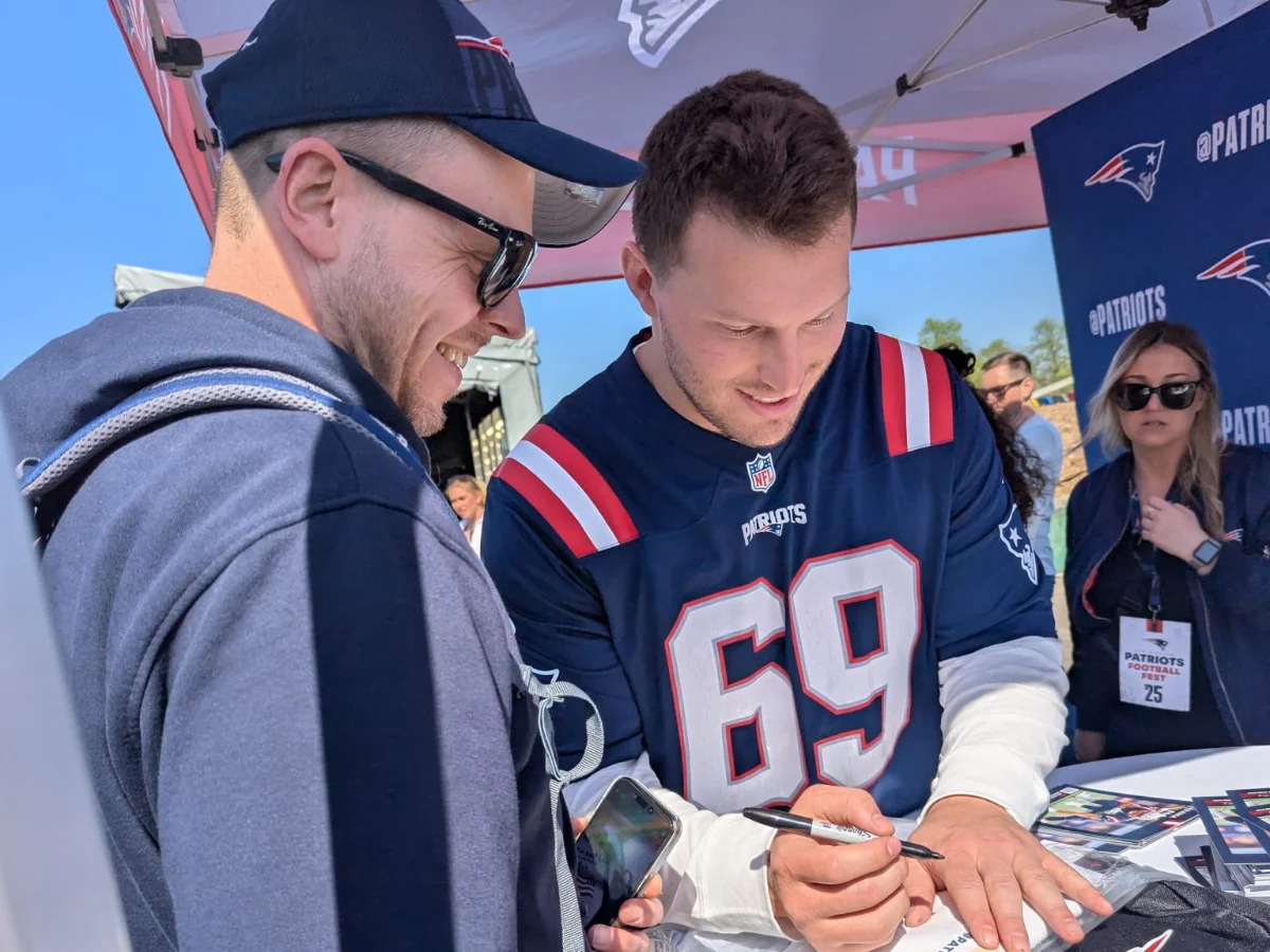 Ein Patriots-Pavillon, in dem ein Mitglied und der ehemalige Spieler Cole Strange steht.