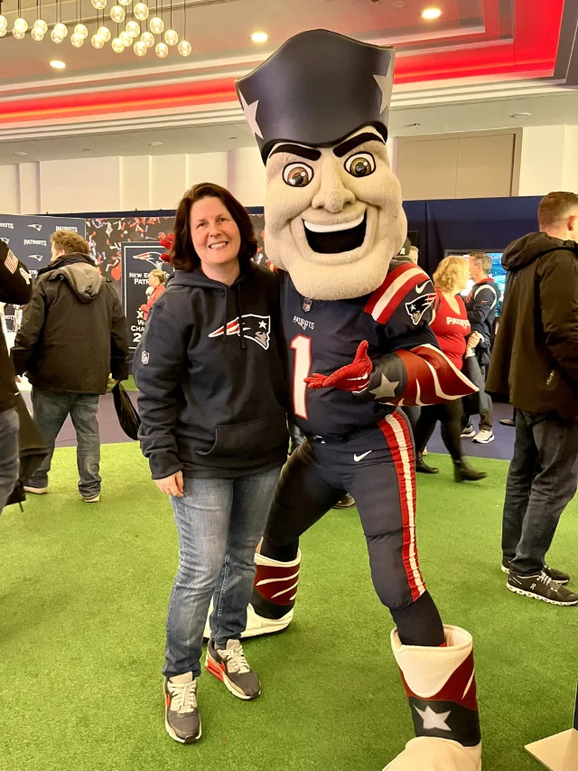 Ein Mitglied posiert mit dem Patriots-Maskottchen.