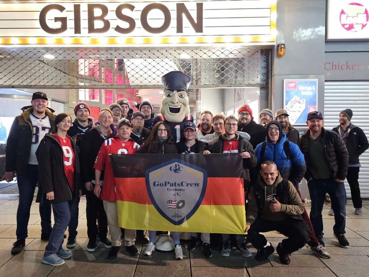 Die GoPatsCrew steht vor dem Gibson mit Pat Patriot und hält die Fanclub-Fahne hoch.