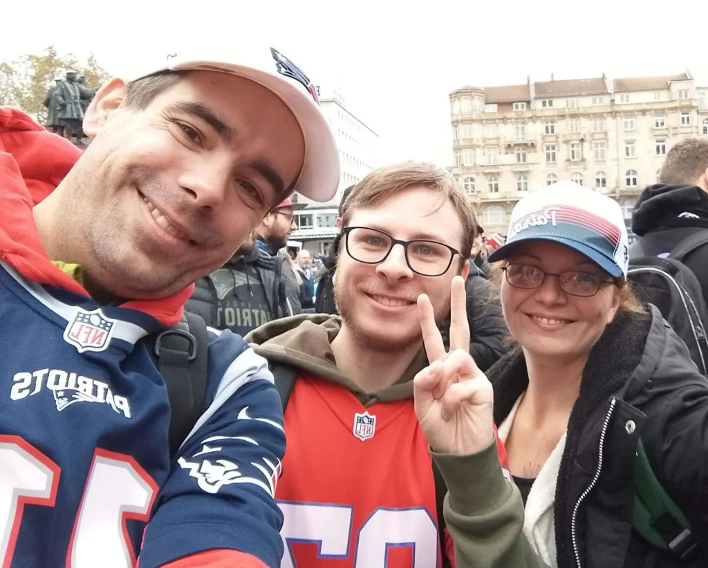 Drei Mitglieder posieren in Patriots-Gear