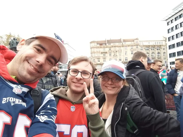 Drei Mitglieder posieren in Patriots-Gear
