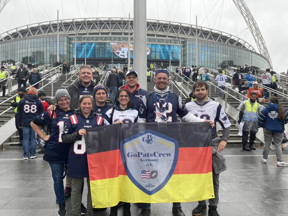 Acht Mitglieder mit einer großen GPC-Fahne vor dem Wembley-Stadion in London.