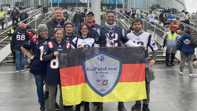 Acht Mitglieder mit einer großen GPC-Fahne vor dem Wembley-Stadion in London.